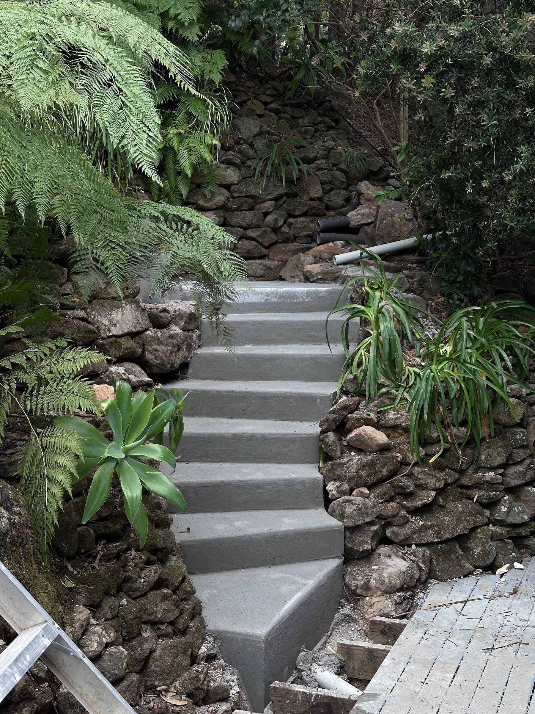 Terraced concrete steps with natural stone retaining walls